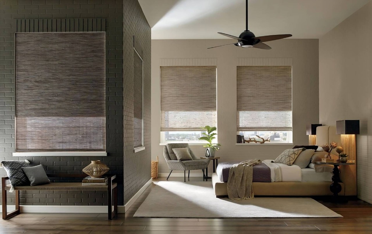 A bedroom with woven shades pulled up and fresh flowers on the nightstand near Honolulu, HI