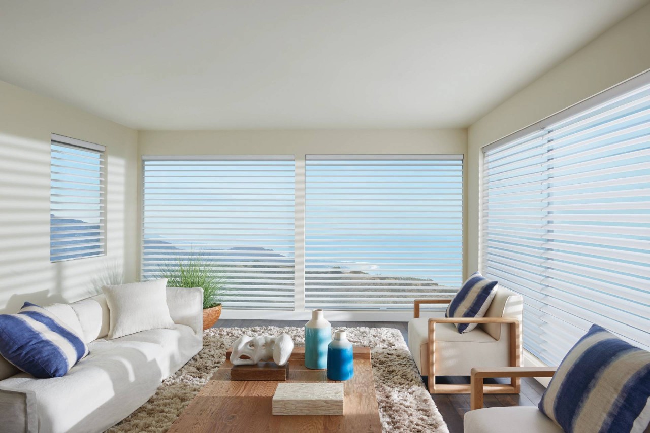 Brightly decorated sunroom with large windows covered by Hunter Douglas Silhouette® Sheer Shades